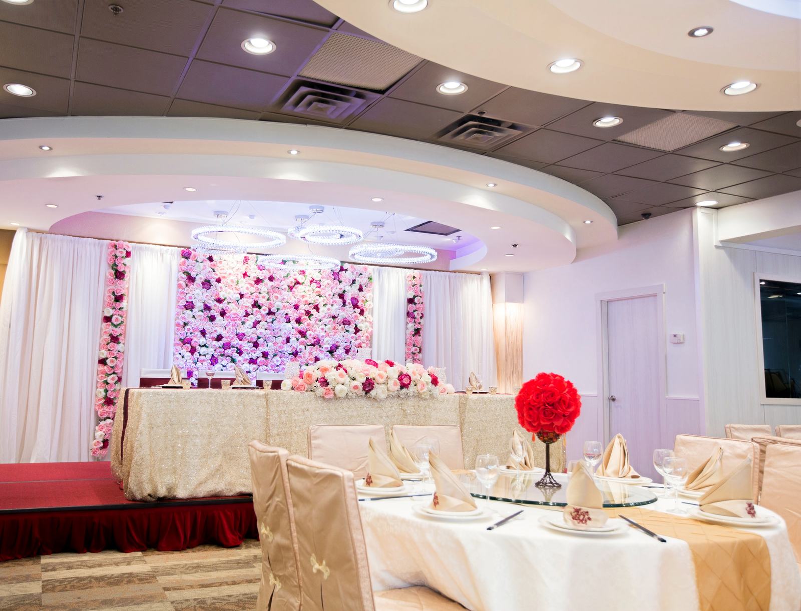 A Neptune banquet room dressed for a wedding with a floral backdrop